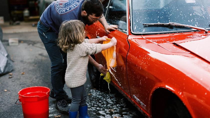 mężczyzna z dzieckiem myją samochód