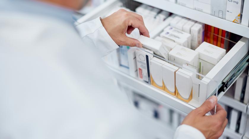 Aptekarzy wyjmujący leki z szuflady