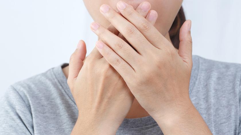 Kobieta zasłaniająca usta