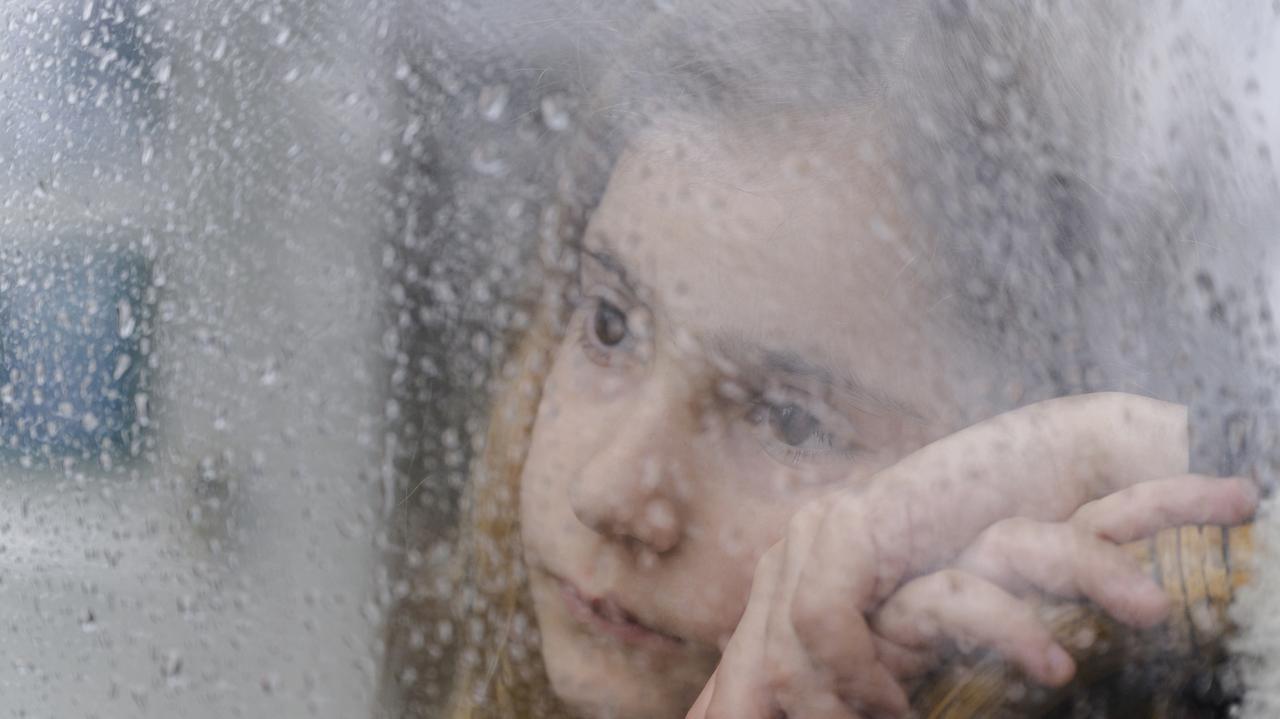 Dziewczynka patrząca przez zaparowane okno