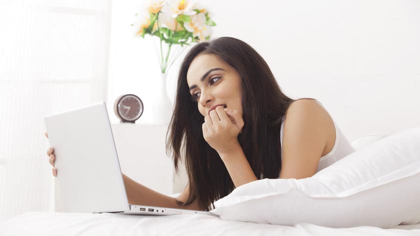 Kobieta wpatrująca się w ekran komputera. Fałszywe konta w mediach społecznościowych. Związki.