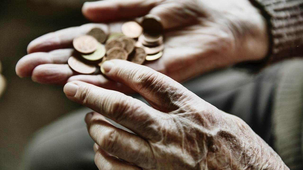 Starsza osoba licząca pieniądze