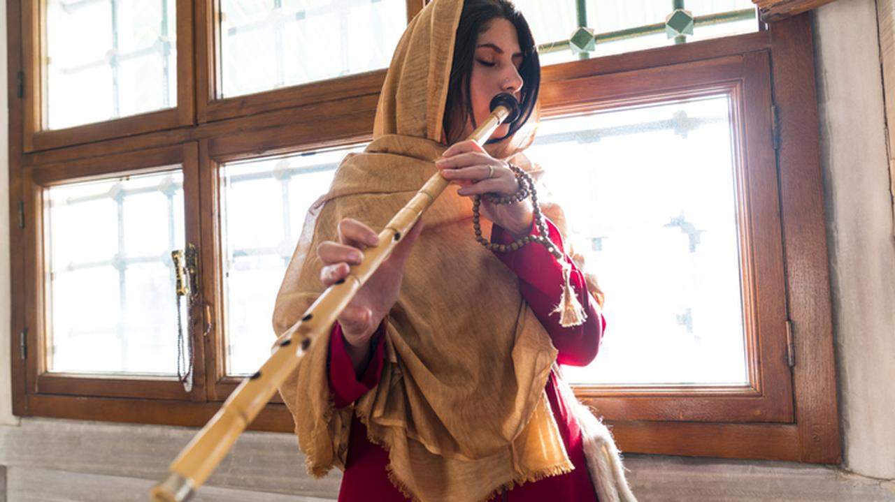 Kobieta grająca na flecie. Muzyka arabska.