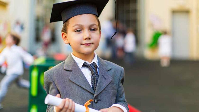 Chłopiec ze świadectwem na zakończenie roku szkolnego