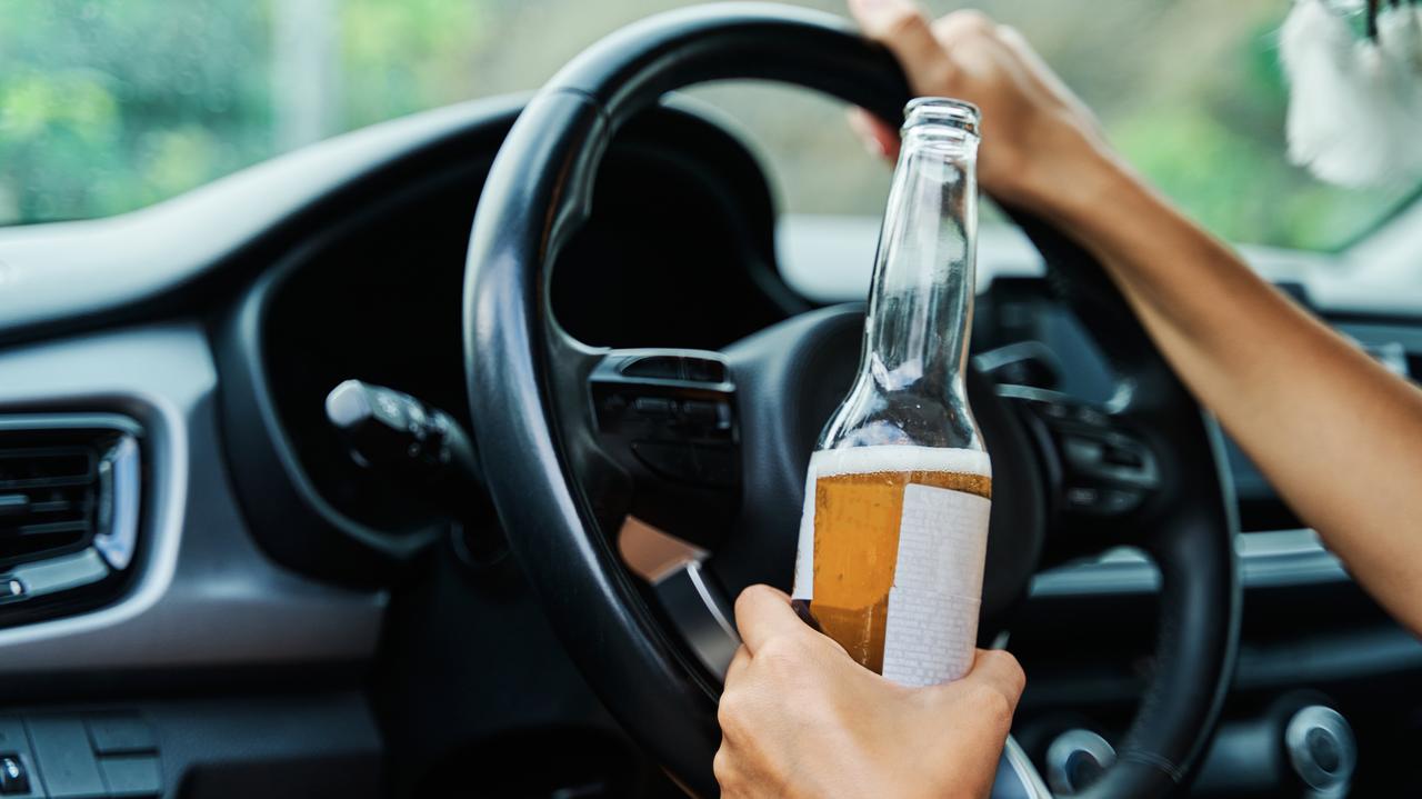 Kierowca z alkoholem w dłoni