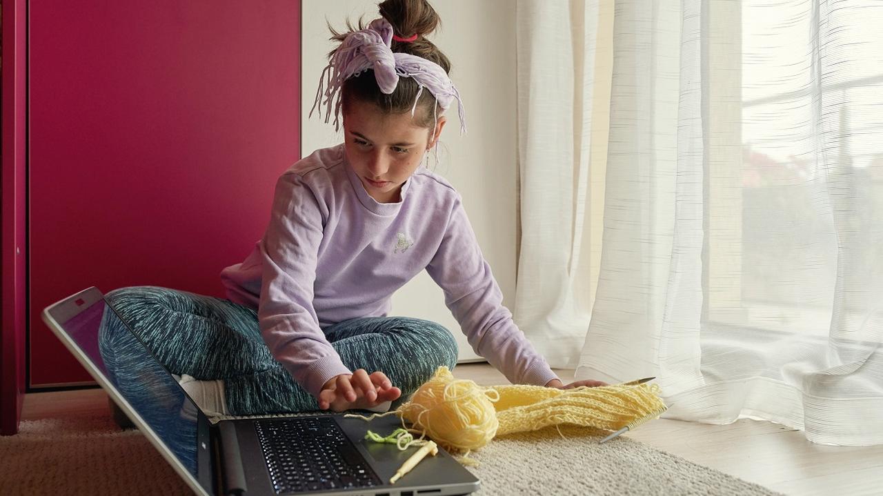 dziewczynka robiąca coś na laptopie