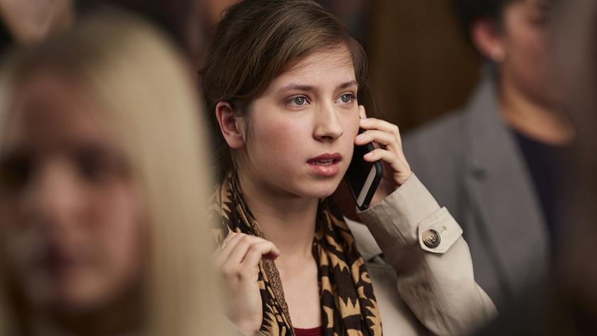 Kobieta w tłumie rozmawia przez telefon