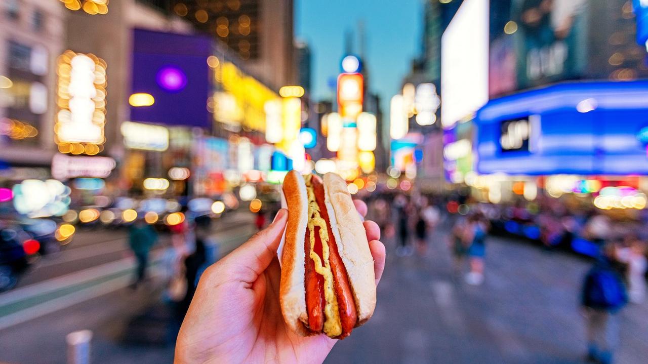 hot dog w dłoni na ulicy w mieście