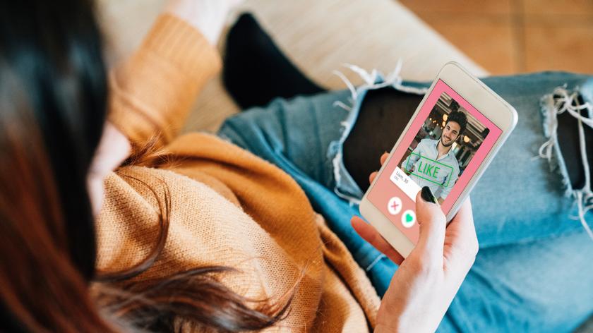 Kobieta przegląda aplikację randkową na telefonie