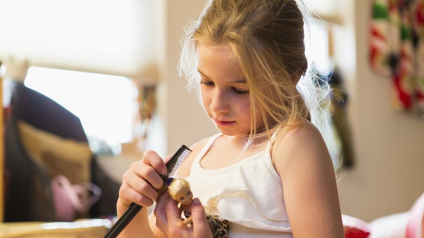 dziewczynka, która bawi się lalką 