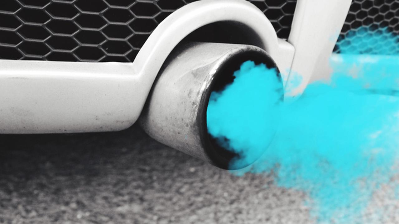 Niebieski dym unoszący się z rury wydechowej samochodu. Motoryzacja.