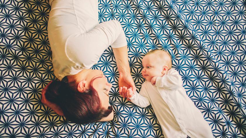 Kobieta leży na łóżku z dzieckiem