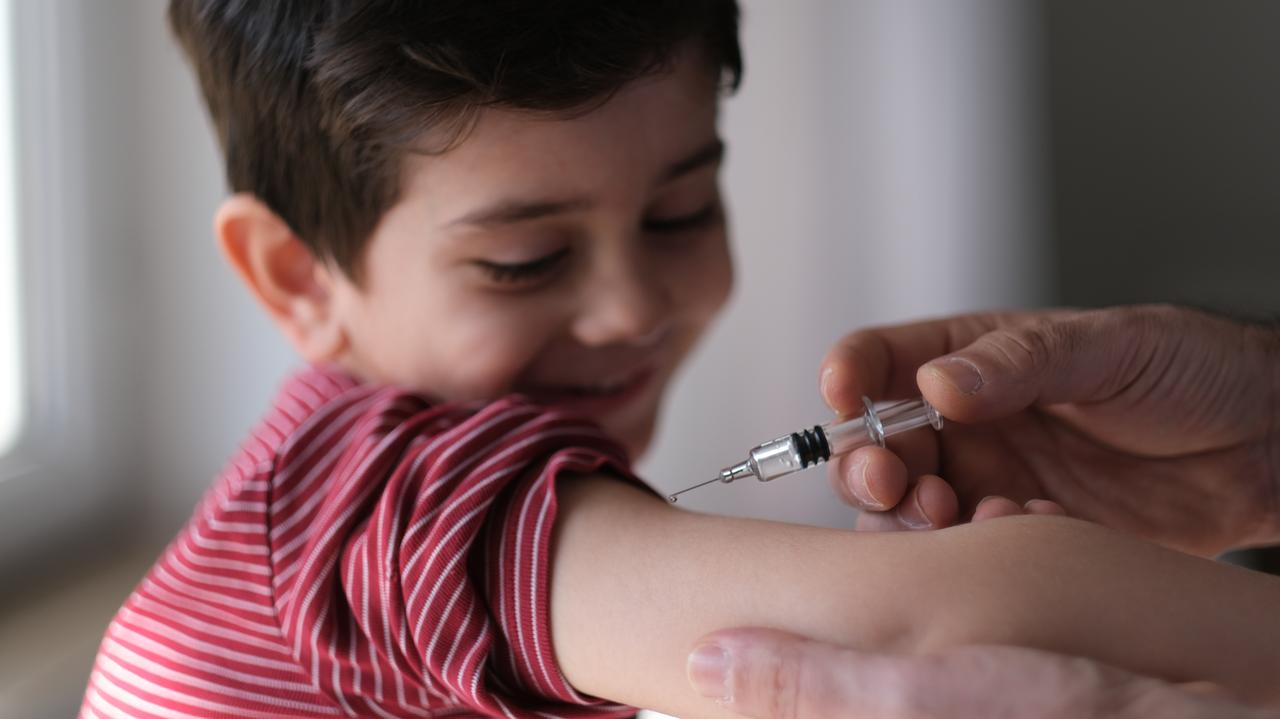 Chłopiec, który otrzymuje szczepionkę przeciwko SARS-CoV-2 