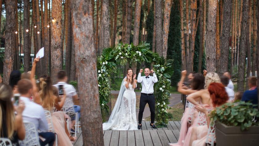 para młoda i goście na ślubie w środku lasu