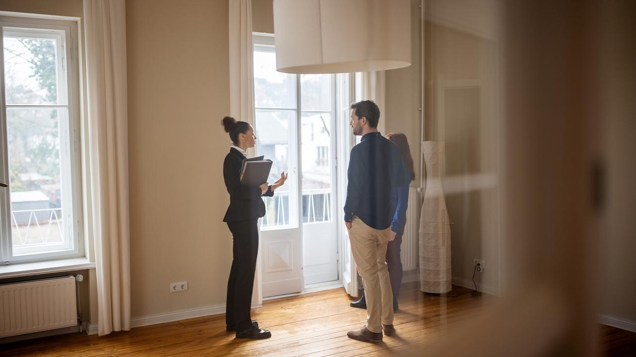 Agent nieruchomości pokazuje klientom mieszkanie