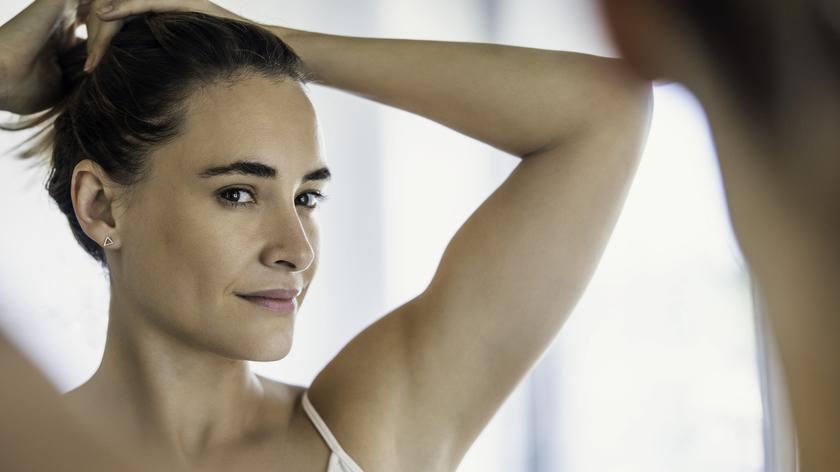 Kobieta upinająca włosy.