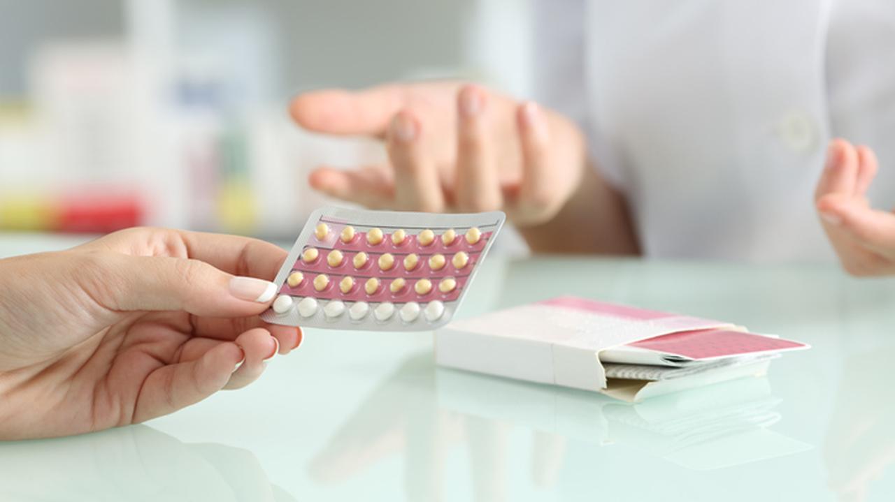 Kobieca dłoń trzymająca listek z pigułkami antykoncepcyjnymi. Leki antykoncepcyjne, antykoncepcja, zapobieganie ciąży.