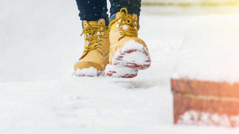 Człowiek idzie w zimowych butach po śniegu