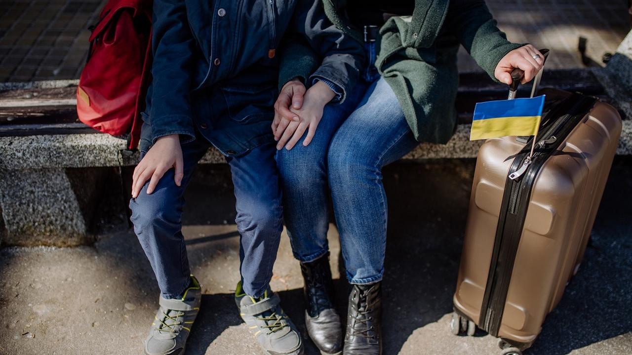 uchodźcy z Ukrainy - matka i syn z walizką