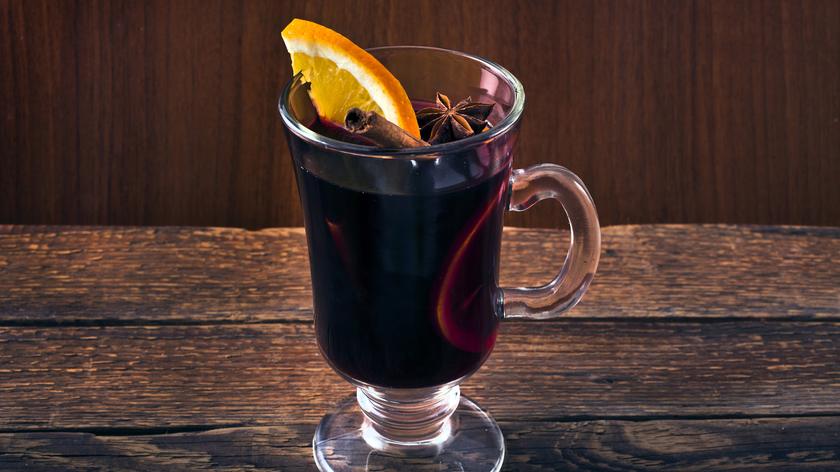 Napój alkoholowy na ciepło z cynamonem i pomarańczą podany w szklance