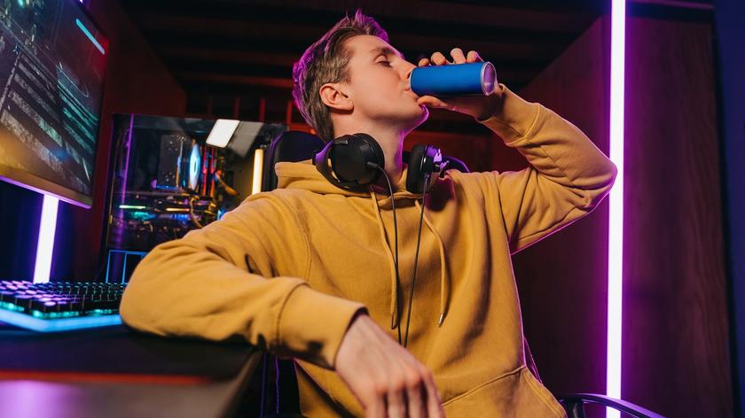 młody mężczyzna, który pije napój z puszki 