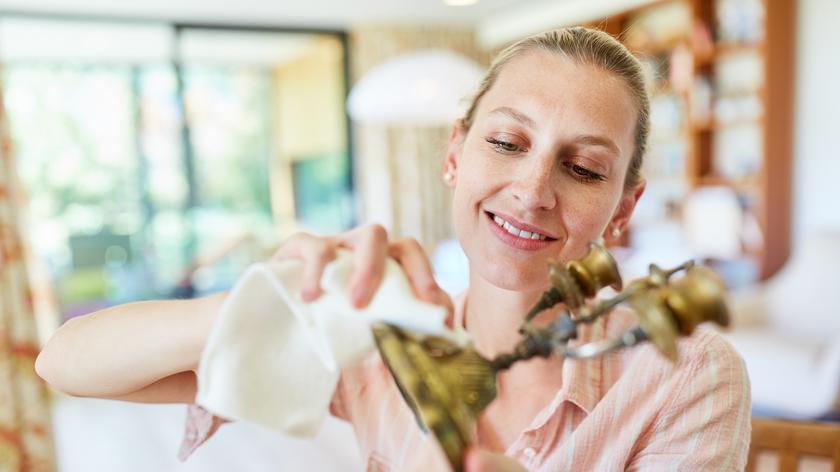 Kobieta czyszcząca mosiężny świecznik