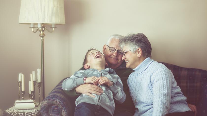 babcia i dziadek przytulają wnuka
