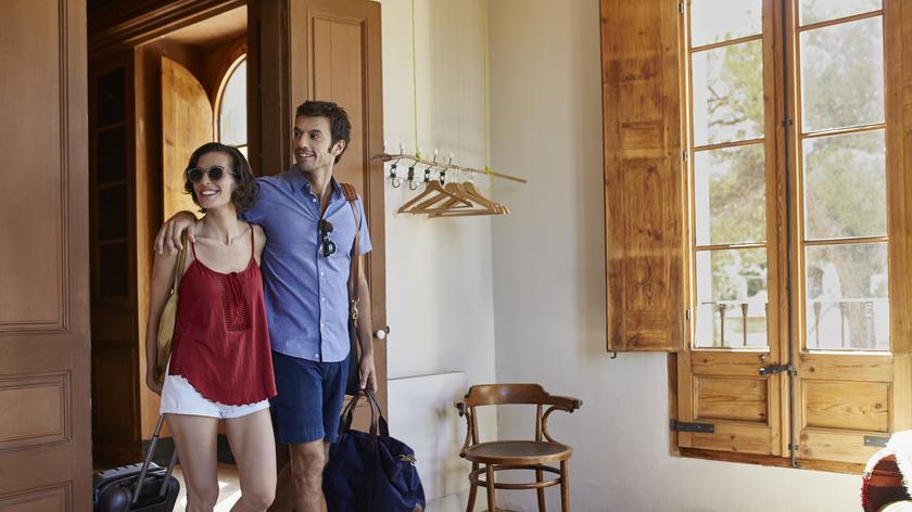 Kobieta i mężczyzna z walizkami w hotelu