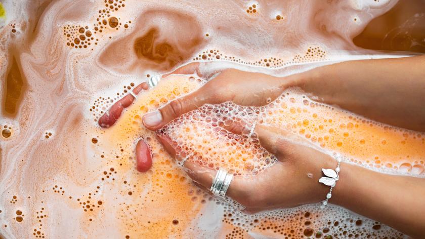 Kobieta w wannie z pomarańczową wodą. 