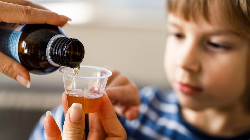 kobieta, która podaje dziecku syrop 