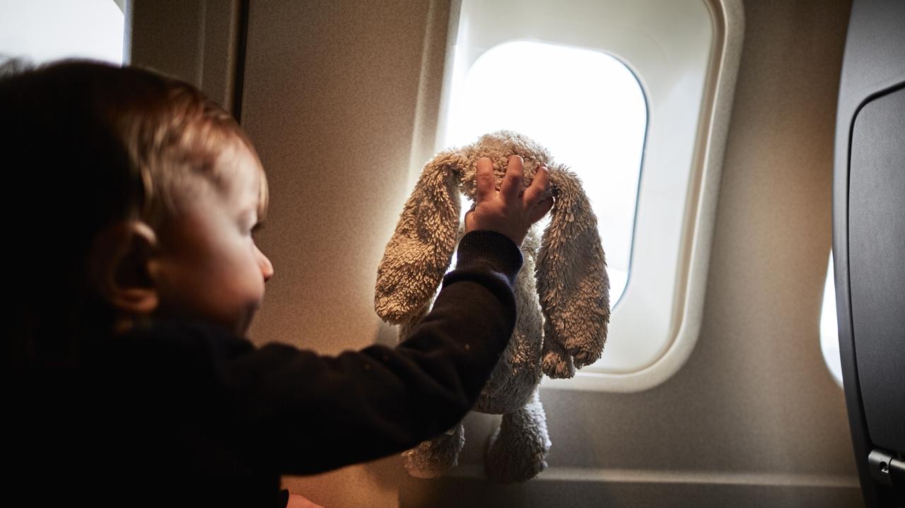 Mały chłopiec z pluszowym króliczkiem na pokładzie samolotu