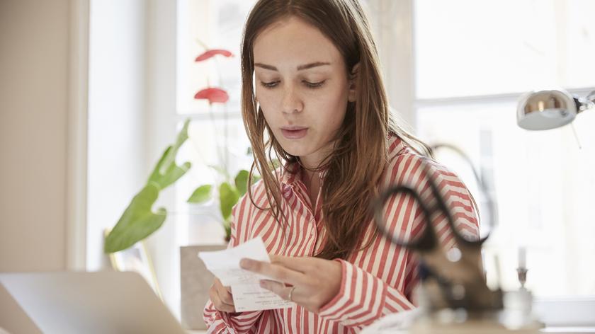Kobieta, która trzyma w dłoni paragon 