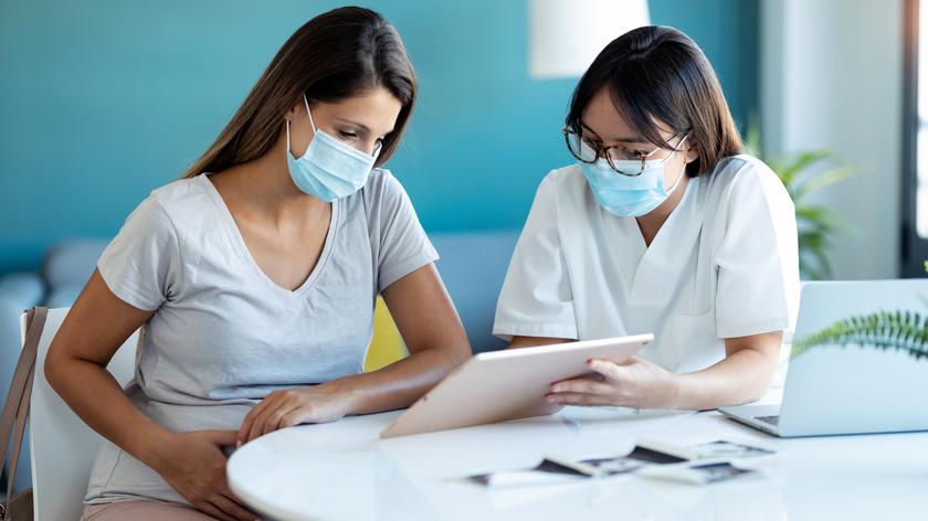 Kobieta w ciąży z lekarką omawiające wyniki