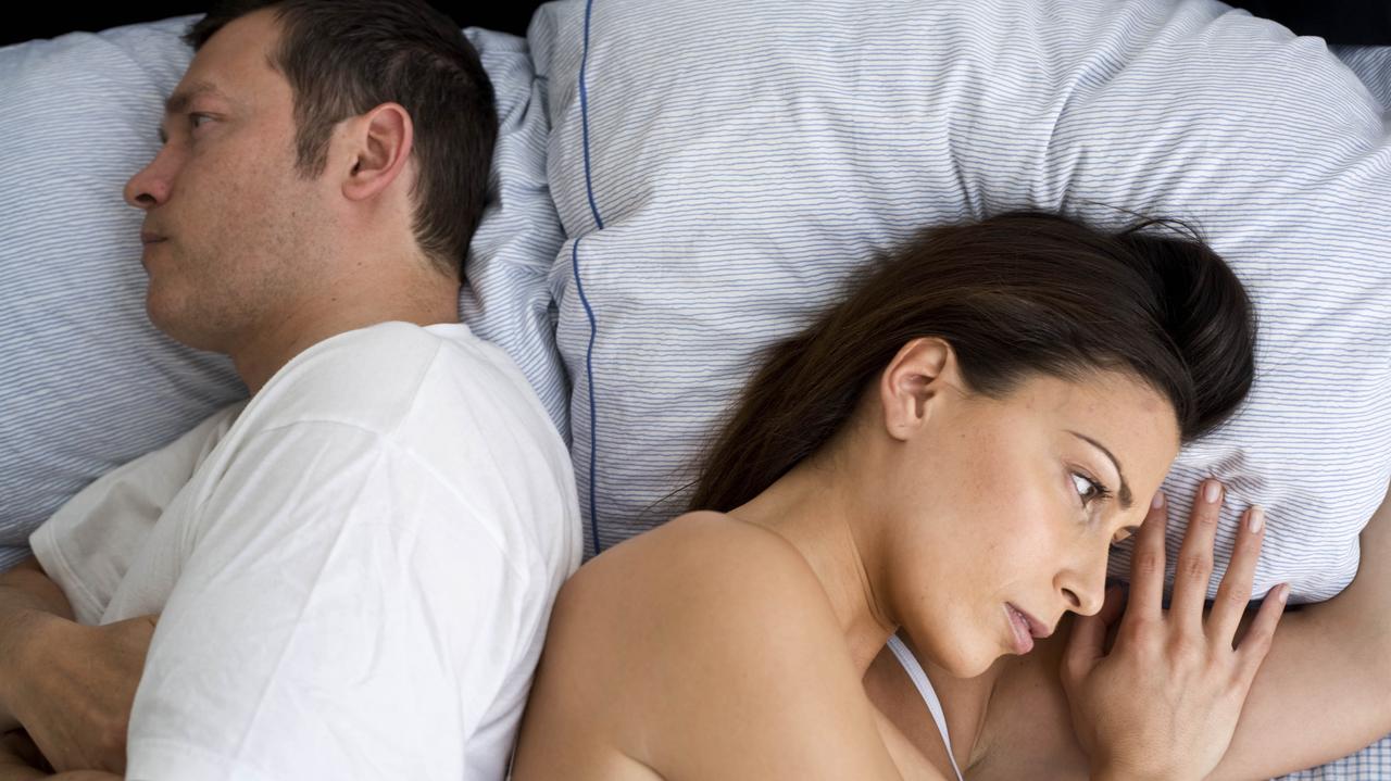 Kobieta i mężczyzna leżą w łóżku odwróceni do siebie plecami