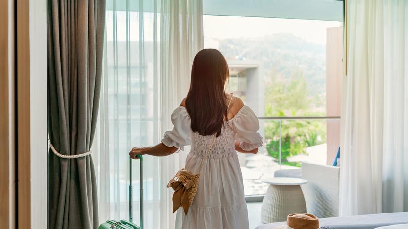 kobieta z walizką w wakacyjnym apartamencie