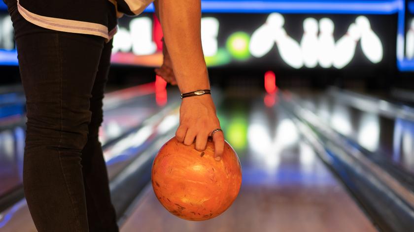 Osoba trzymająca kulę do kręgli przed rzutem