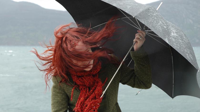 Wietrzna pogoda, kobieta z parasolką