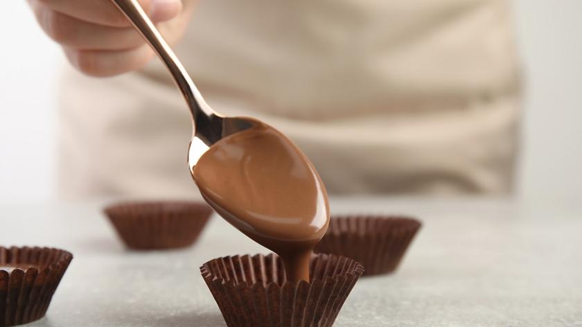 Osoba napełniająca papilotki czekoladą