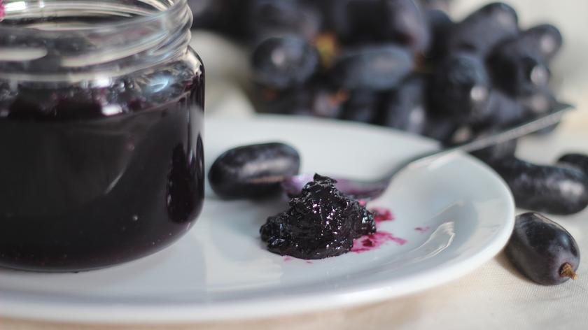 Dżem winogronowy w słoiku i na łyżeczce