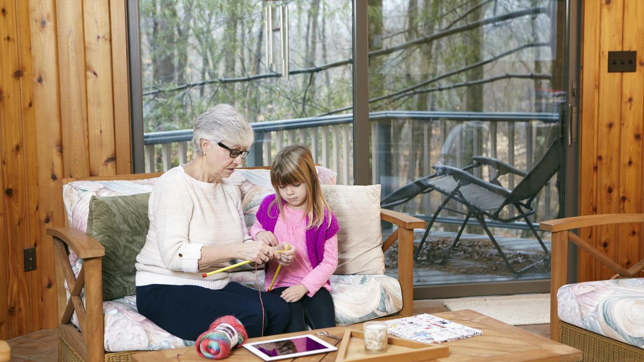 Babcia pokazująca wnuczce jak robić na drutach