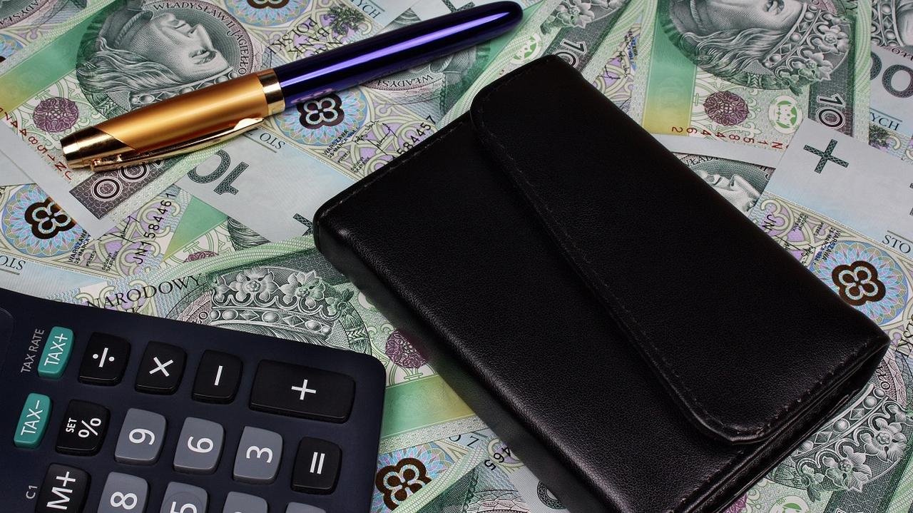 Kalkulator i portfel leżący na pieniądzach