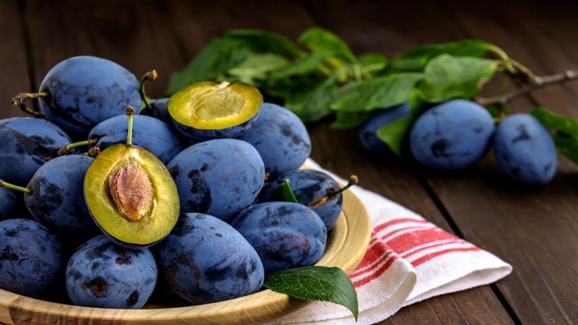 Śliwki podane na drewnianym talerzu