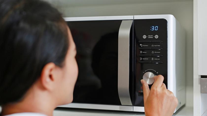 Osoba włączająca mikrofalówkę
